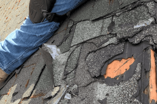 Several layers of old asphalt shingles peeled back on a Bellevue farmhouse roof, showing how many roofs were stacked on top of each other