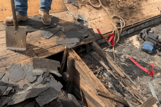 Old shingle layers being torn off a Bellevue farmhouse roof, exposing the wood plank decking underneath