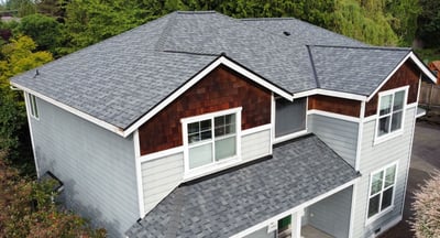 Two-story home with a new gray architectural asphalt shingle roof over gray and cedar-shake siding