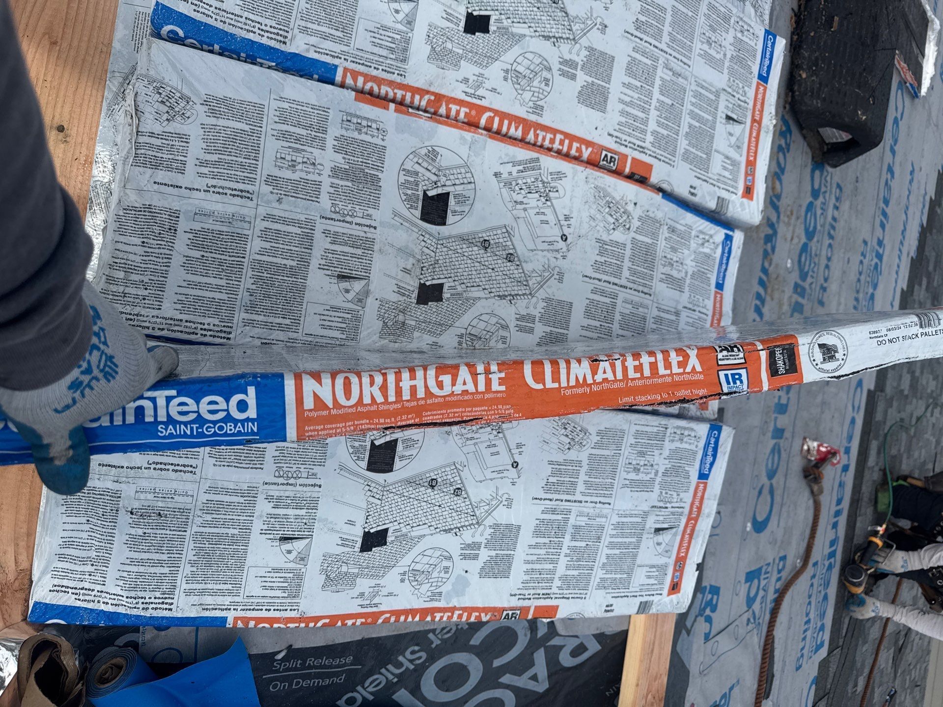 NorthGate ClimateFlex shingle bundles stacked on a roof deck before a CertainTeed roof installation