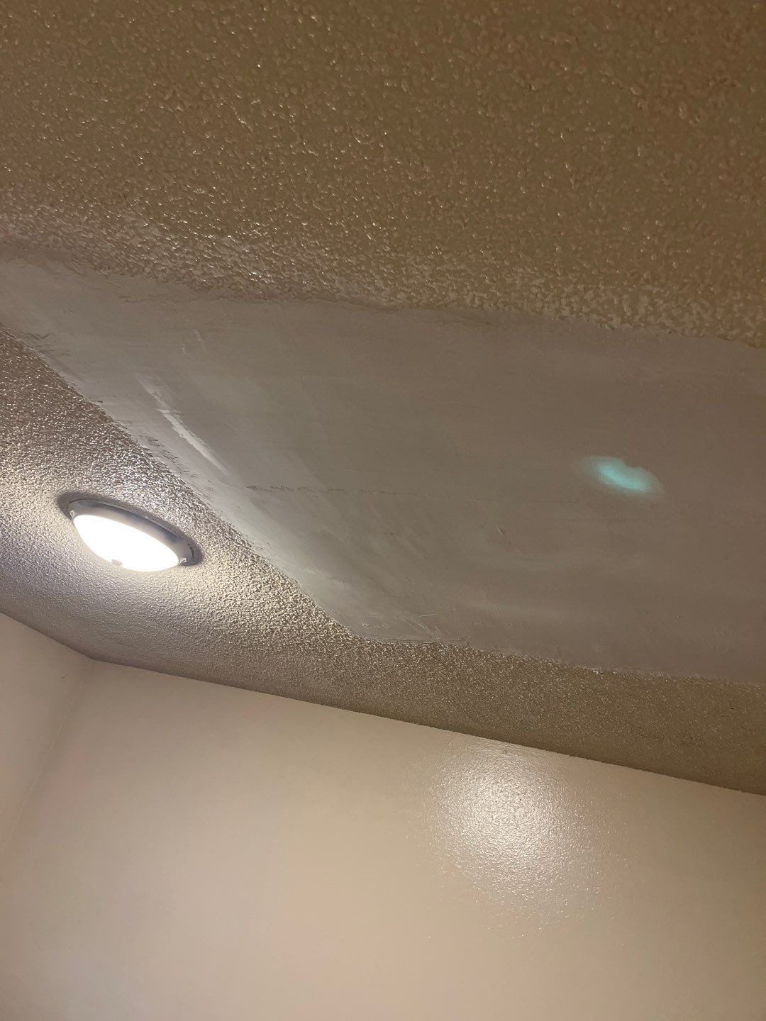 The same hallway ceiling with the opening closed and patched smooth with new drywall.