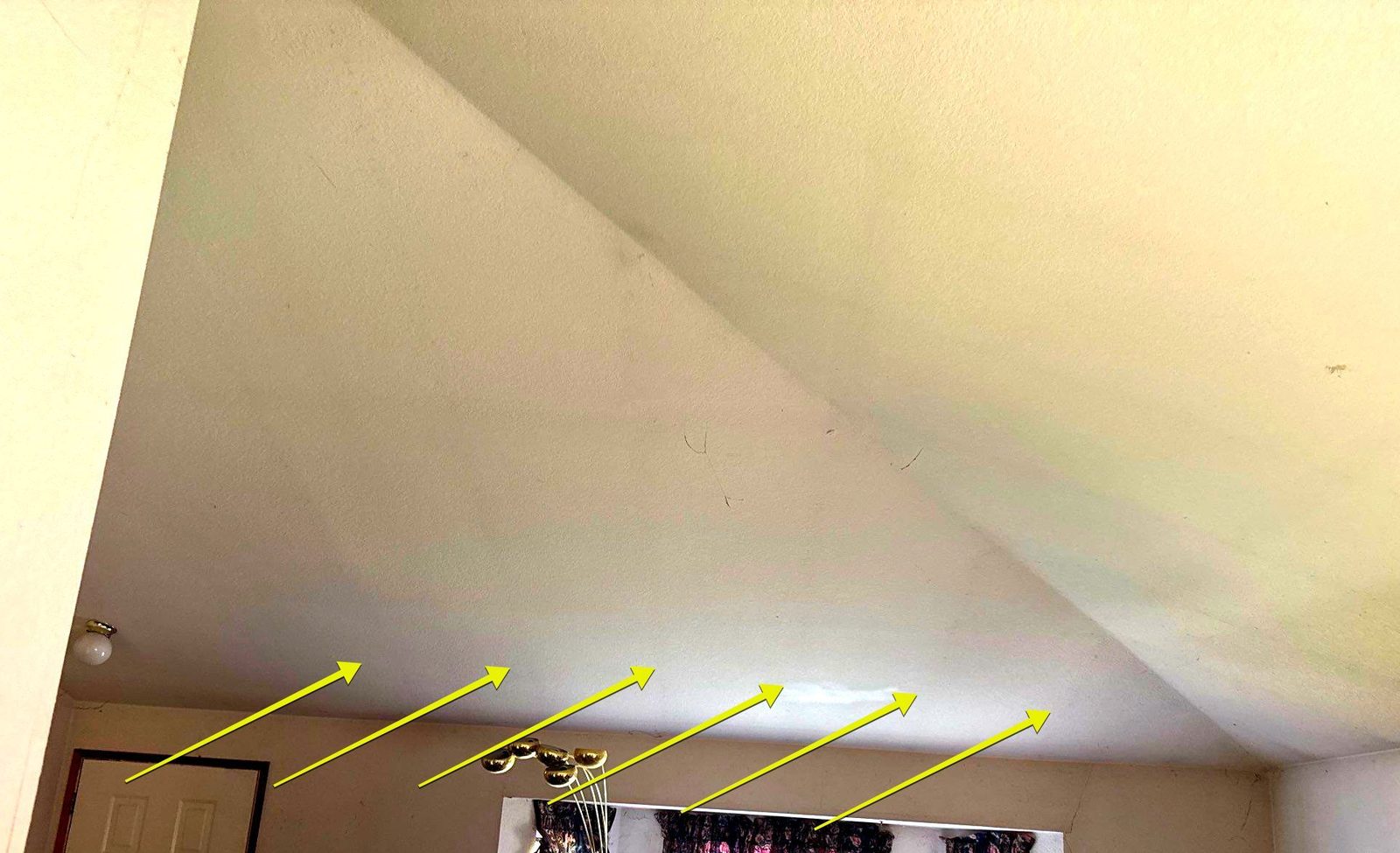 Vaulted living-room ceiling with arrows marking faint stripes of ghosting