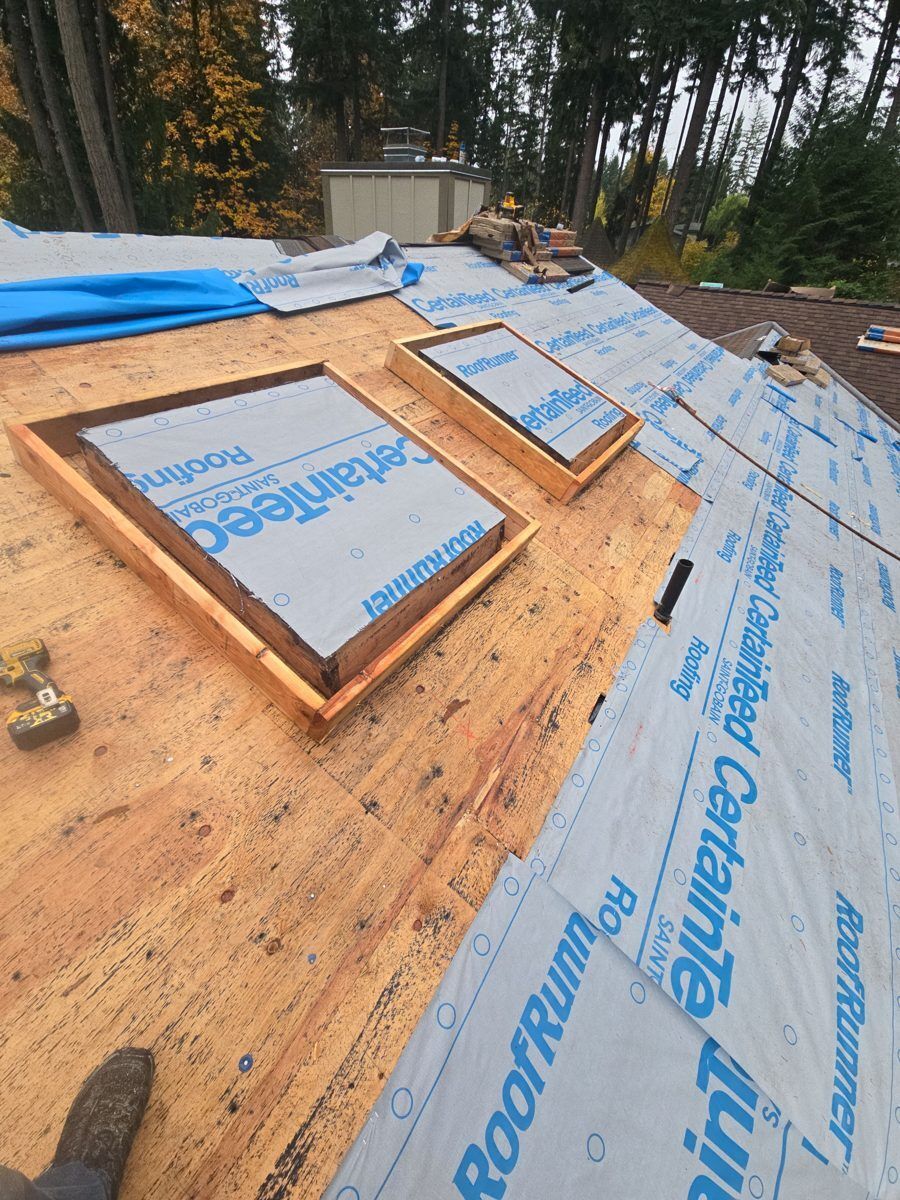 New skylight frames built and wrapped in underlayment on a roof deck before the shingles go on