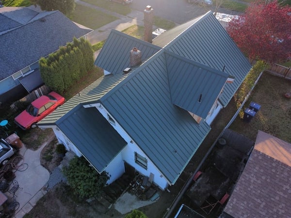 Dark green metal roof on a white house