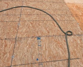 Olympia: new roof sheathing on a steep roof, with a safety rope across it.